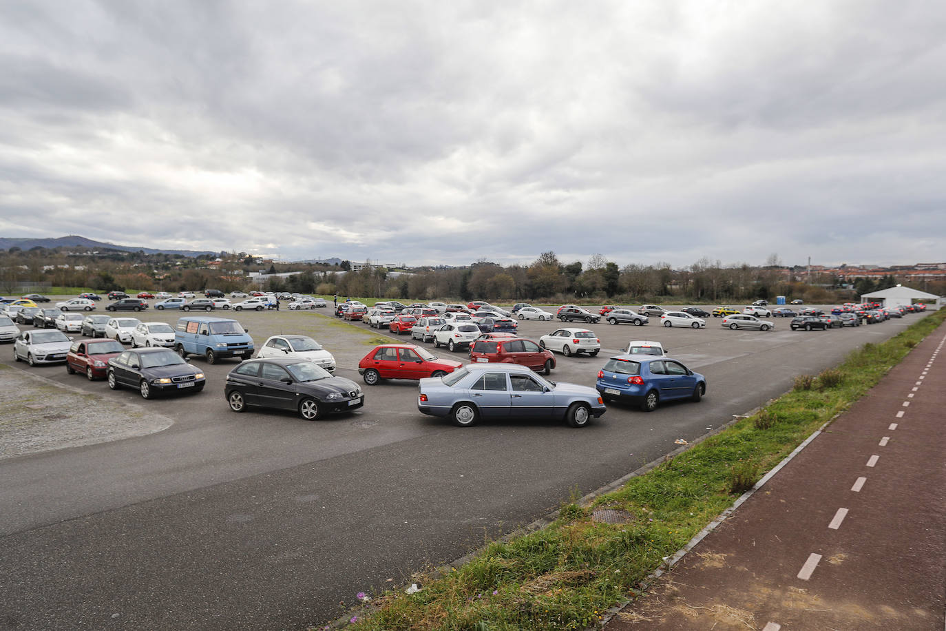 La actividad está siendo intensa en los autocovid de Gijón. Este mismo jueves, agentes de la Policía Local han tenido que acudir al instalado en la Marina Civil para formar una suerte de circuito y ordenar el tráfico. 