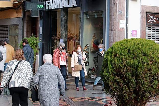 Gente paseando por las calles de Avilés con mascarillas.