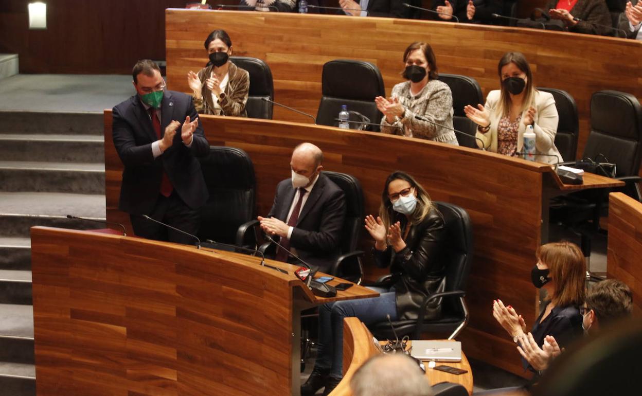 Adrián Barbón, al frente de la bancada socialista, aplaude junto a sus compañeros tras la votación.