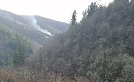 Al fondo, el incendio en Irrondo (Cangas del Narcea), visto desde Besullo, 