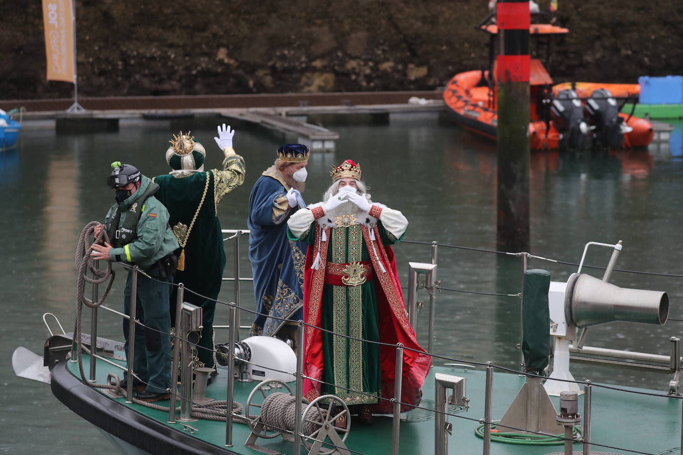 Los Reyes Magos atracaban en el puerto de Gijón bajo la lluvia sobre las 11 de la mañana mientras centenares de niños coreaban lo nombres de Sus Majestades.