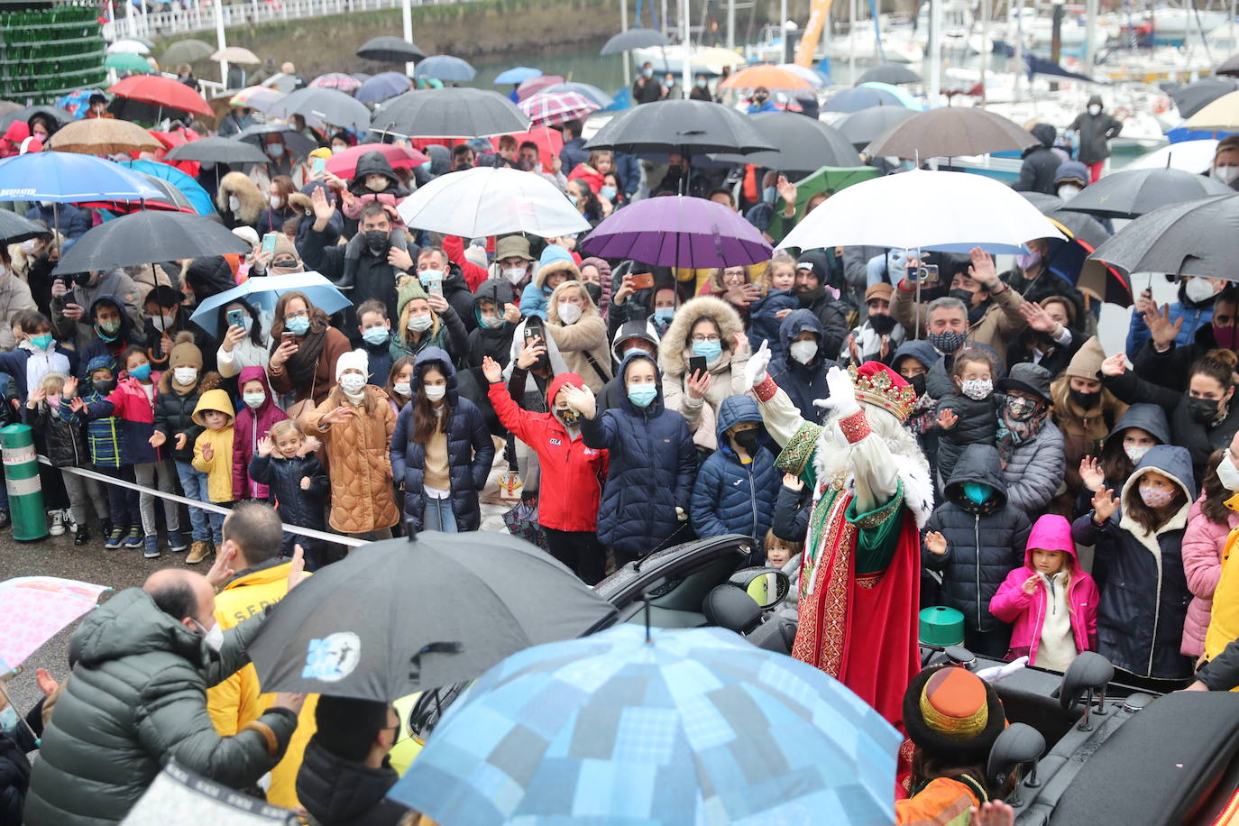 Los Reyes Magos atracaban en el puerto de Gijón bajo la lluvia sobre las 11 de la mañana mientras centenares de niños coreaban lo nombres de Sus Majestades.