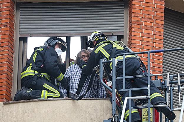 Vicente Moirón en el momento en que es rescatado por los bomberos, que intentan tranquilizarlo. 