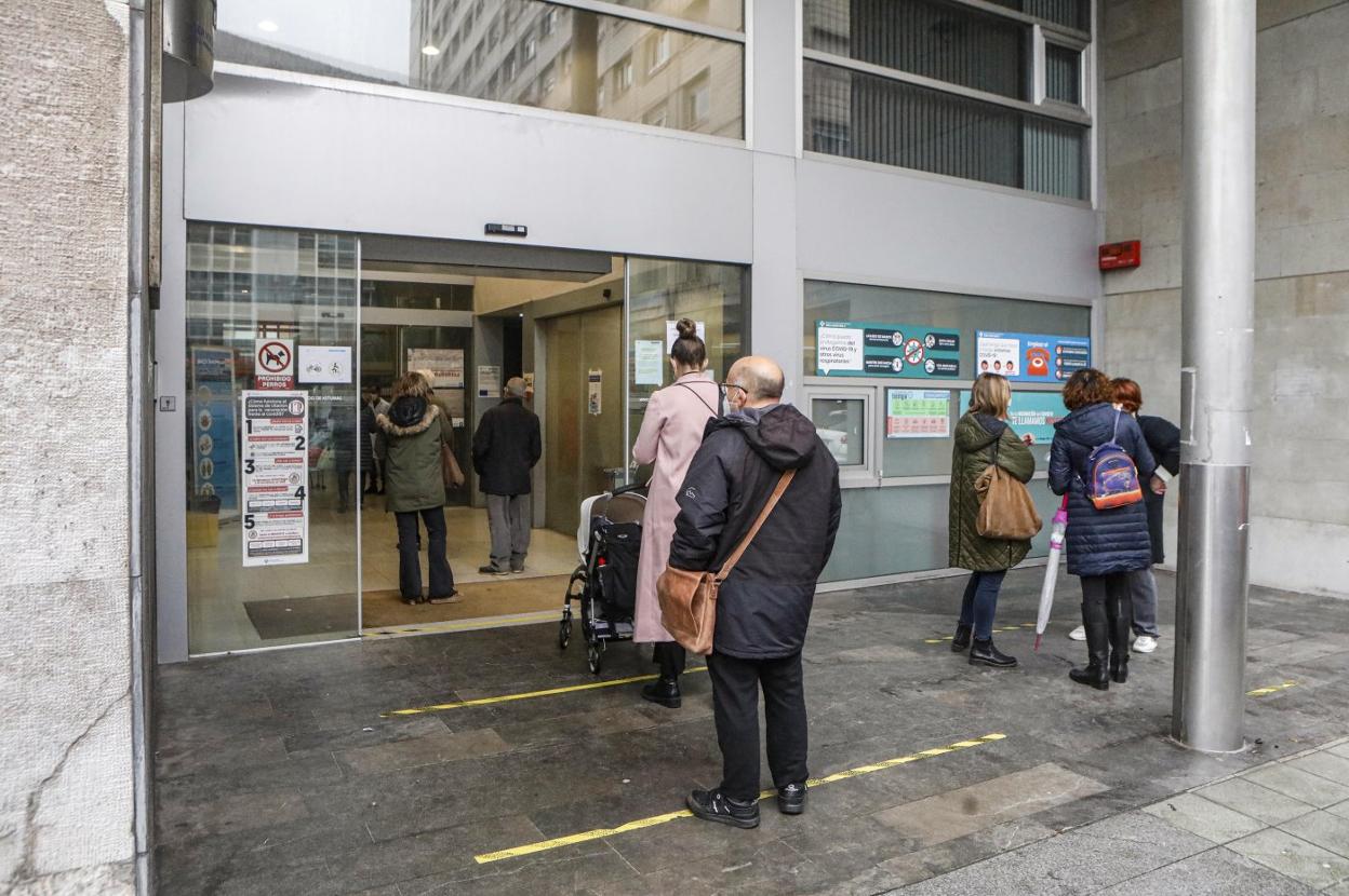 Usuarios del Centro de Salud Puerta de la Villa, en Gijón, esperan su turno para acceder al equipamiento. 