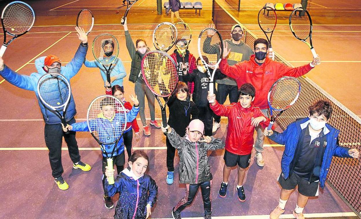 Niños y niñas que empiezan en el tenis, con sus monitores, en el Club de Tenis de Gijón. 