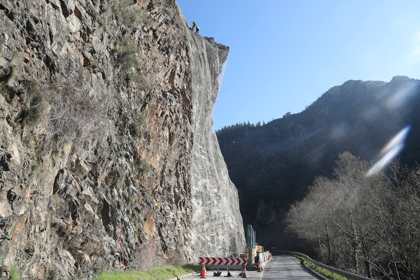 Fotos: Los operarios fijan los bulones y las redes de cotención en la AS-15