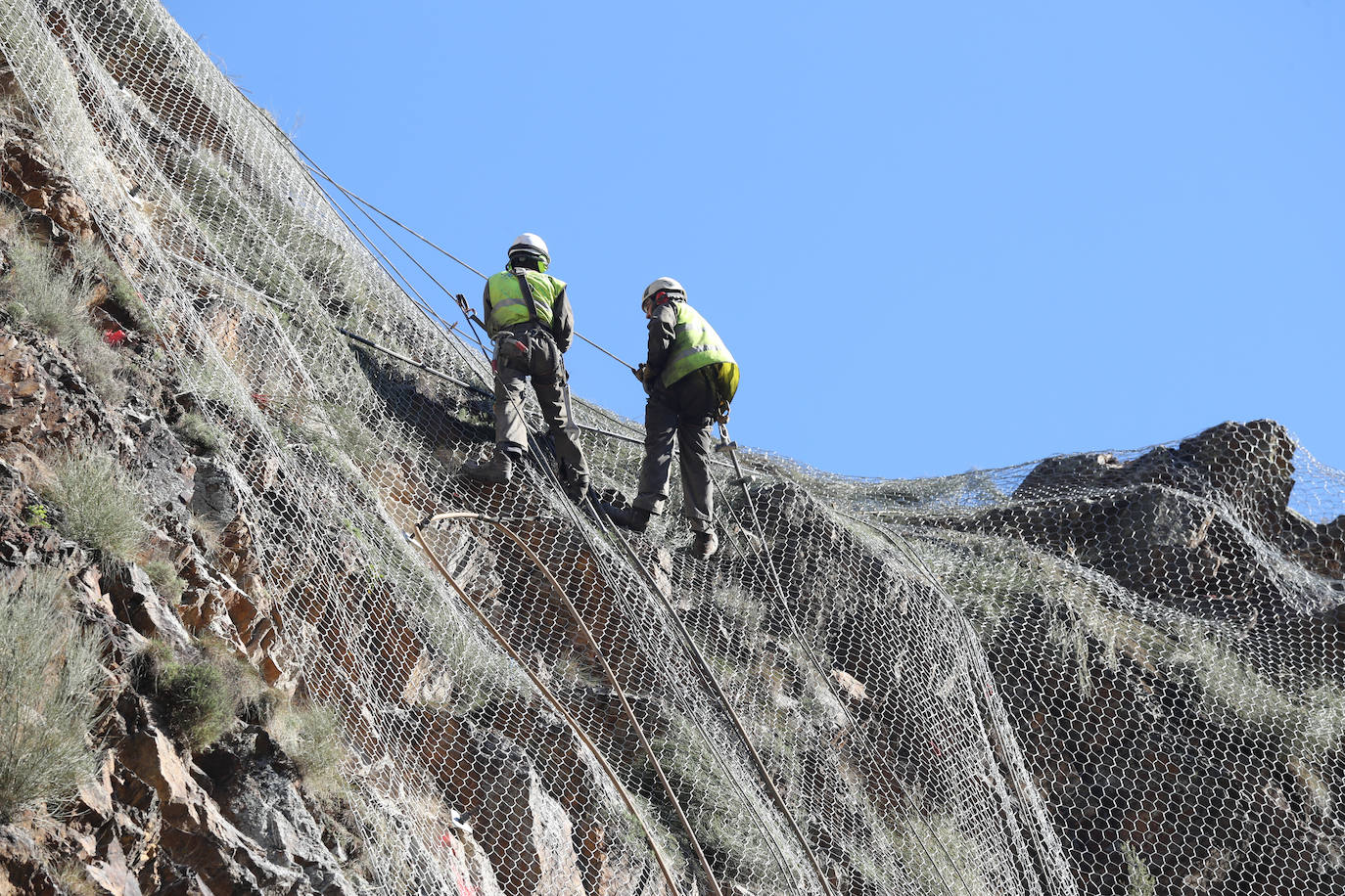 Fotos: Los operarios fijan los bulones y las redes de cotención en la AS-15