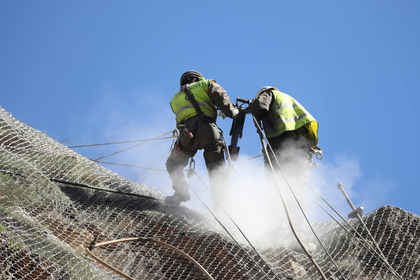 Fotos: Los operarios fijan los bulones y las redes de cotención en la AS-15