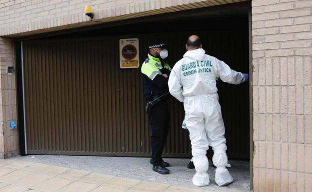 La Guardia Civil en la entrada de la cochera del edificio donde se ha encontrado el cadáver de la víctima.