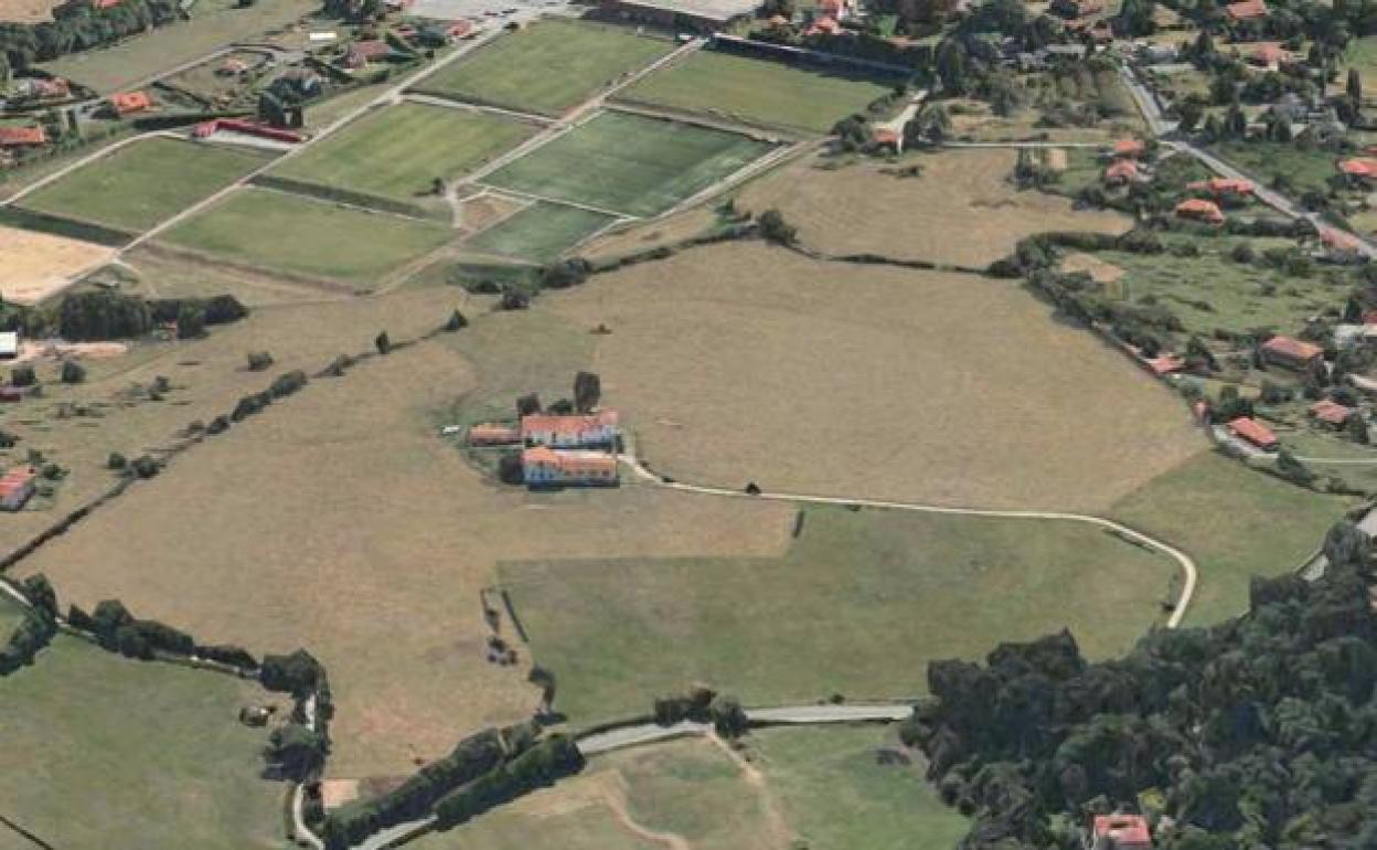 Imagen de la finca coloquialmente conocida como 'Las Palmeras', en primer término, con la Escuela de Fútbol de Mareo al fondo. 