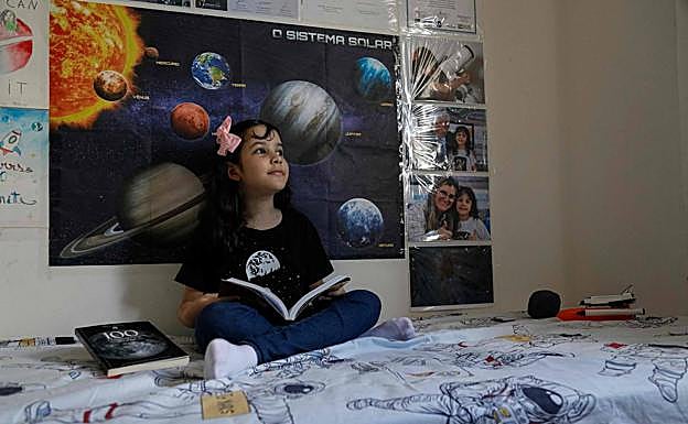 Nicolinha, en su habitación, rodeada de naves espaciales e imágenes del universo