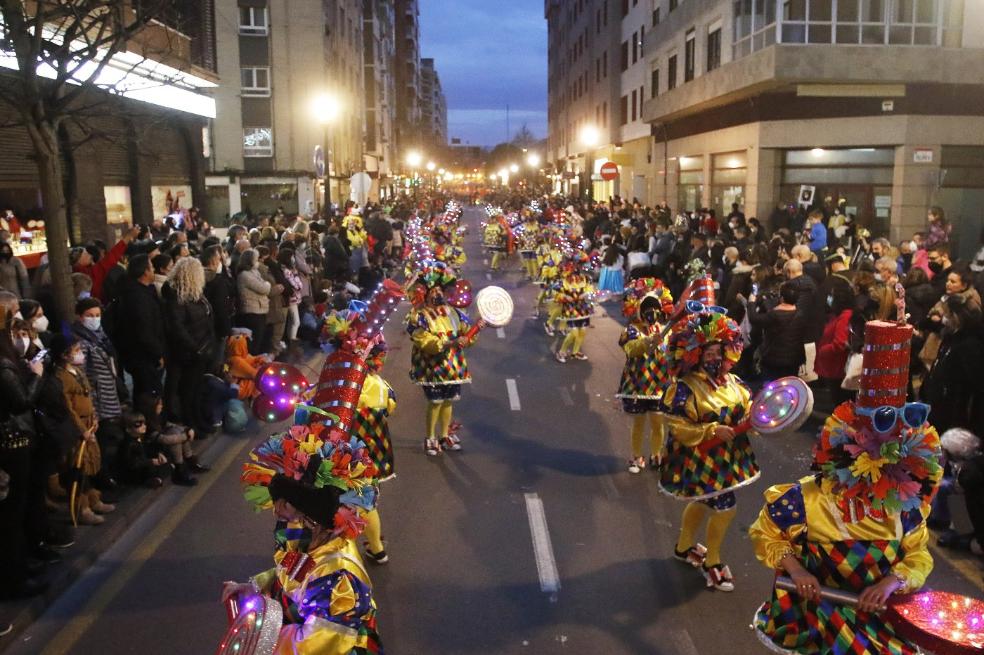 La Asociación Juvenil San Nicolás llevó al desfile su representación 'Descajonados de la risa', con numerosos arlequines de colores y grandes sombreros y piruletas luminosas. 