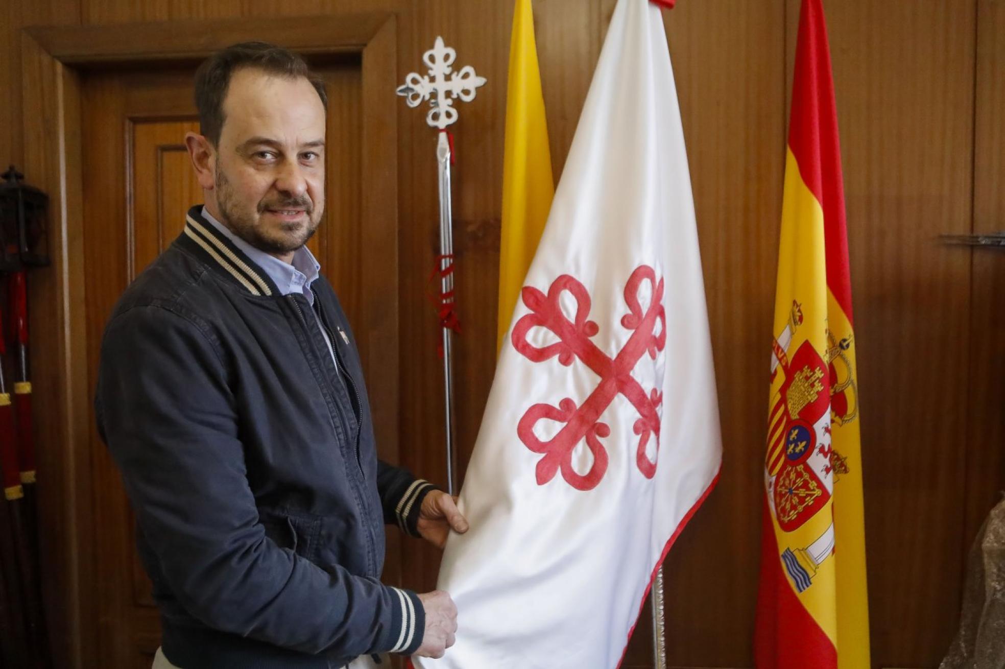 Ignacio Alvargonzález sostiene la bandera de la Santa Misericordia (Gijón). 