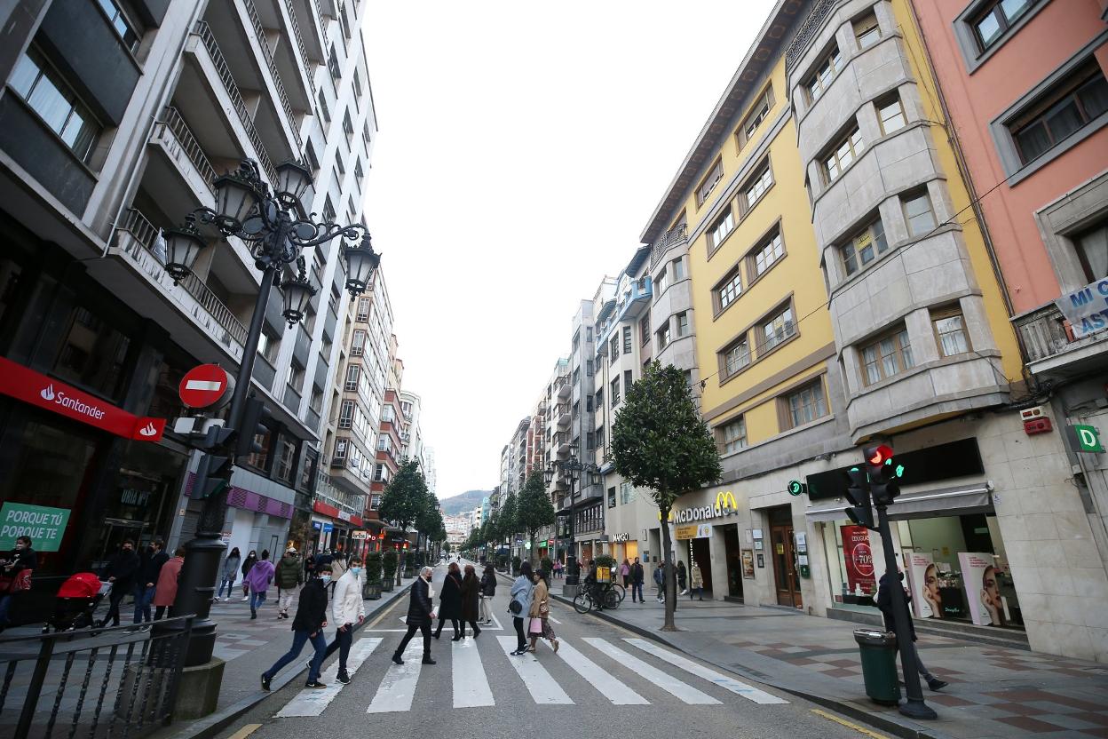 Peatones cruzan por uno de los pasos de cebra de la calle Uría. 