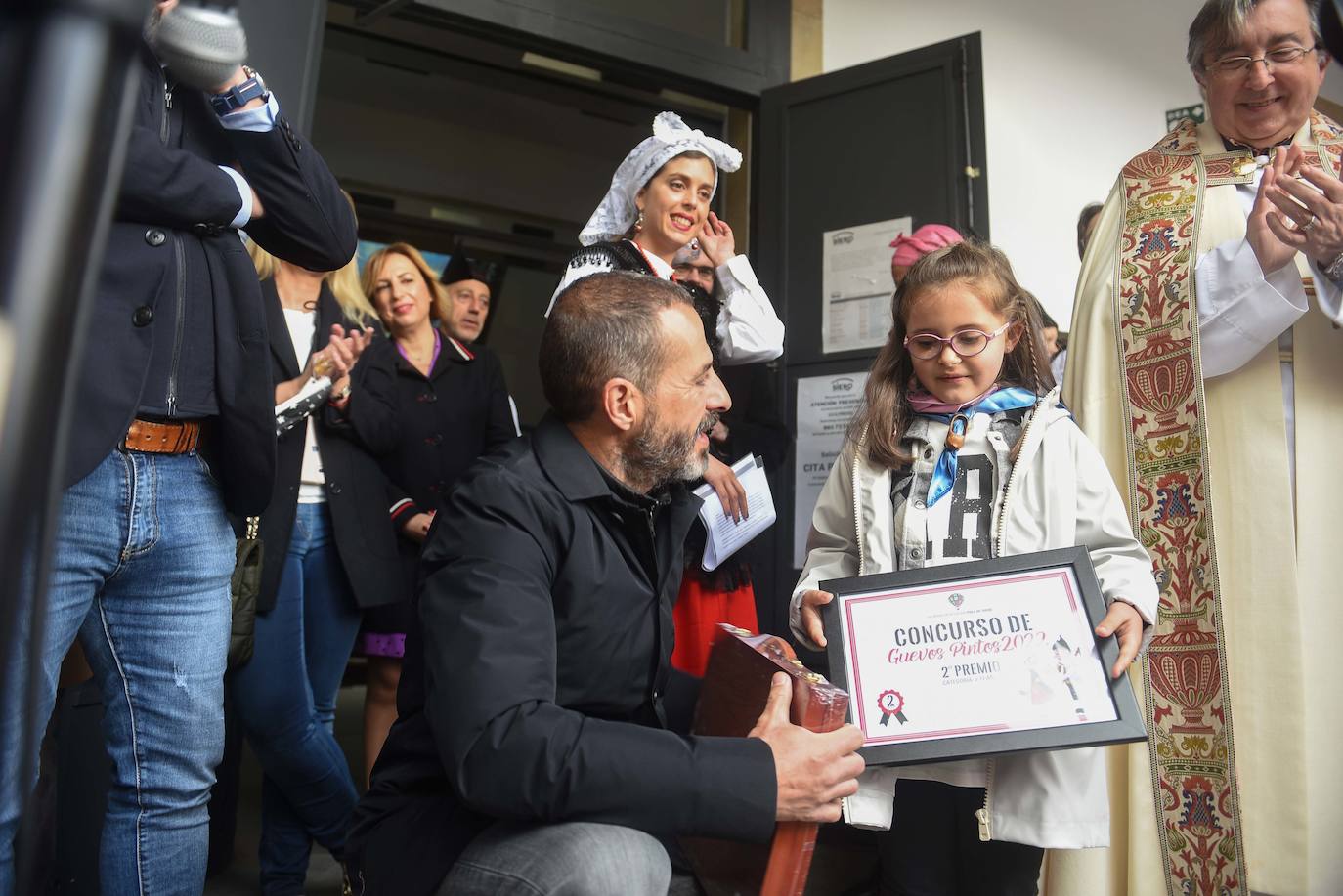 Los polesos ponen «al mal tiempu bona cara» e inauguran la jornada festiva brindando con sidra bajo el paraguas. El párroco Fermín Riaño, resumía esta mañana en su primera bendición de los Güevos Pintos «en vivo y en directo» el sentir de todos los polesos tras una pandemia llena de «allegríes y penes, congoxes y esperances».