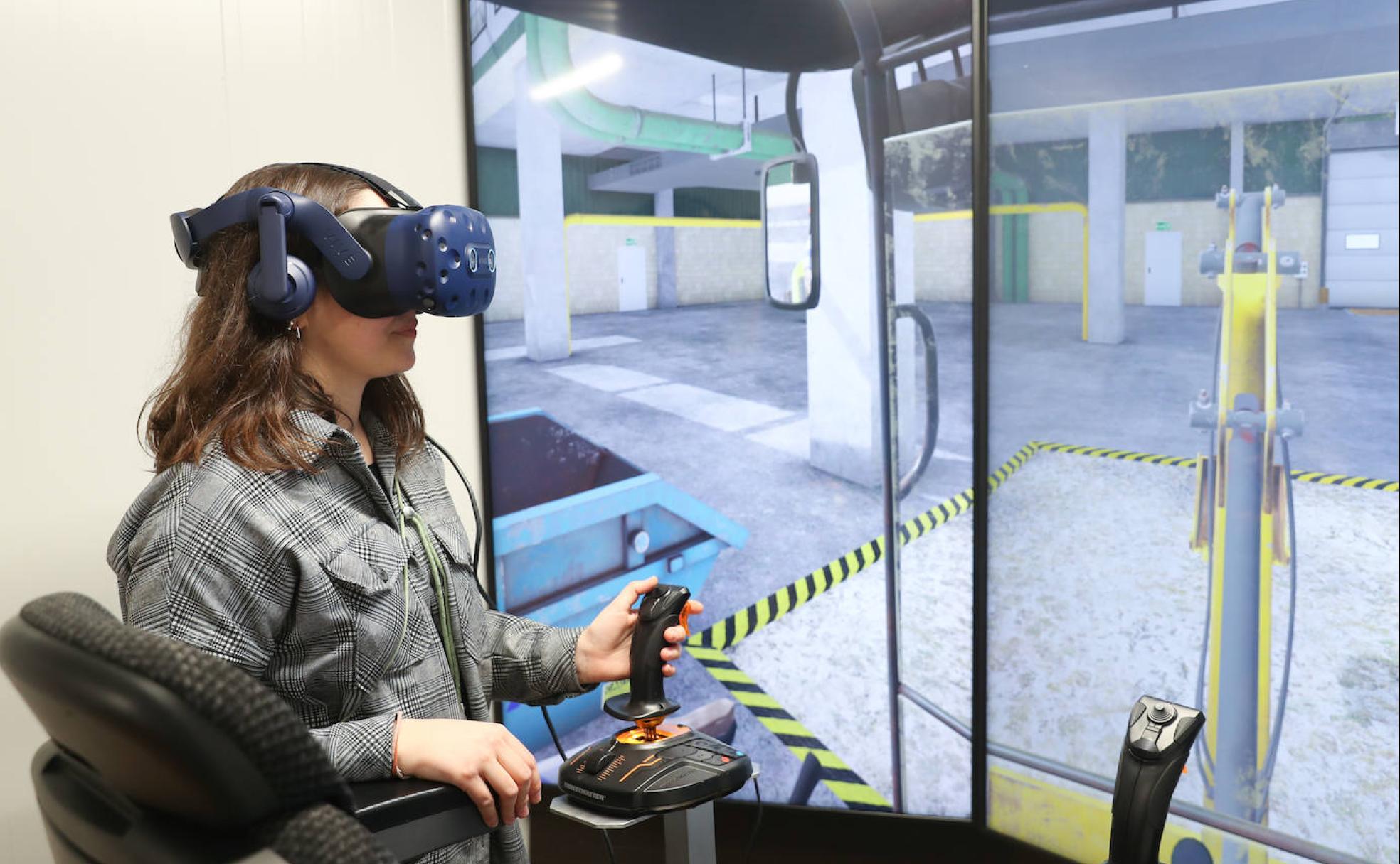 María Pérez, con las gafas virtuales, maneja el simulador con el 'joystick'.