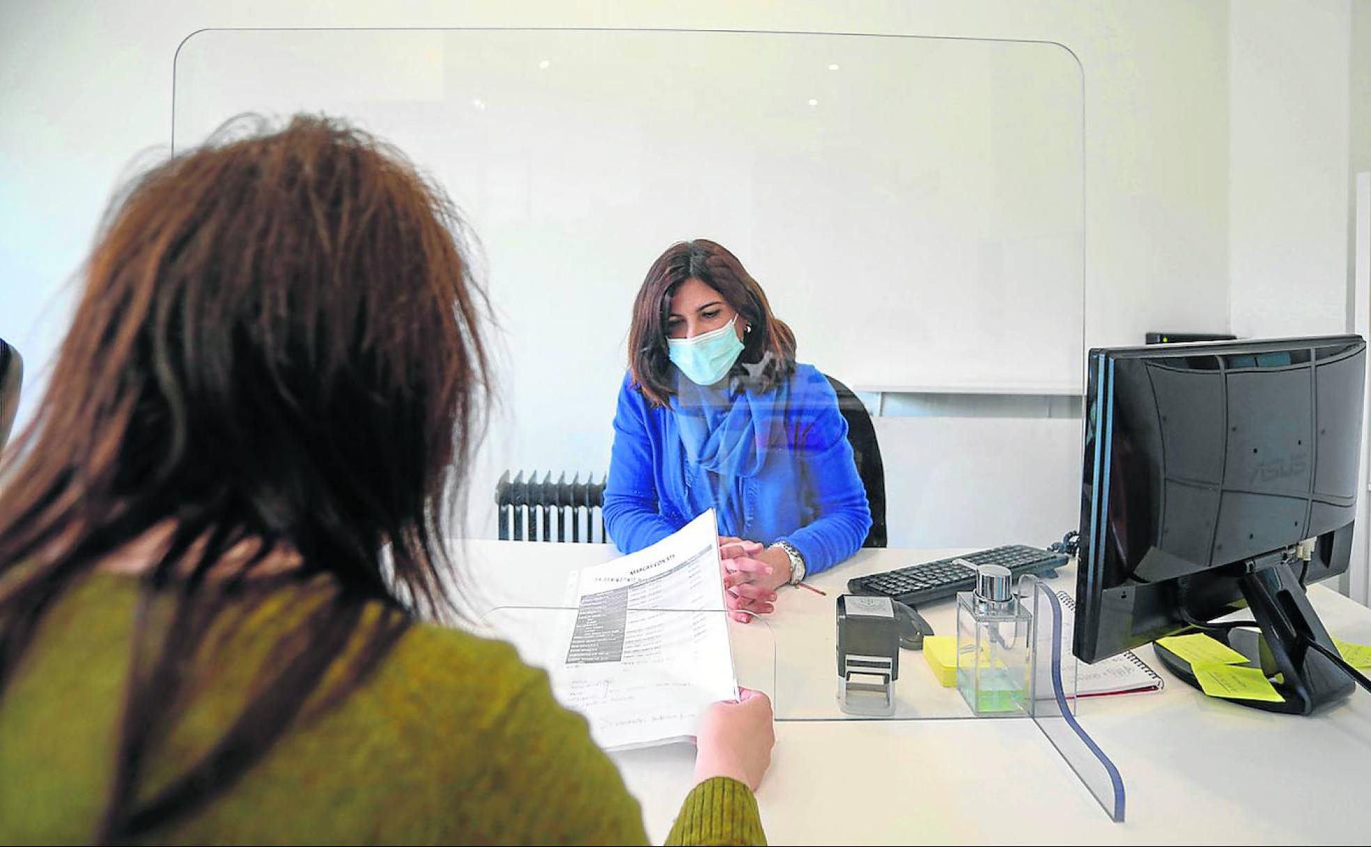 Una usuaria realiza una consulta en el centro de consumidores de Gijón.