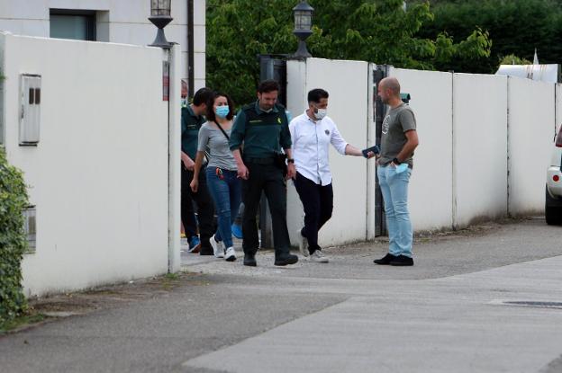 Agentes de la Guardia Civil salen de la vivienda del matrimonio tras inspeccionar el inmueble, acompañados de familiares de las víctimas del trágico suceso. 