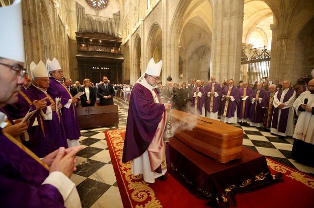 El arzobispo de Oviedo, Jesús Sanz Montes, perfuma con incienso el féretro de Gabino Díaz Merchán durante el rito de despedida. 