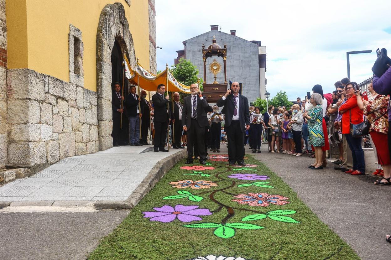 La procesión avanza sobre la alfombra a la salida de la iglesia de San Félix de Lugones. 