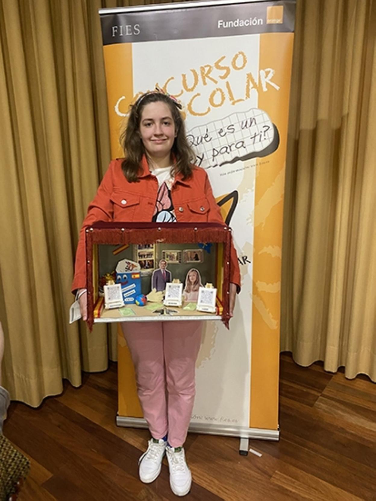 La estudiante Inés Blanco enseña el trabajo que le enseñará próximamente al monarca. 