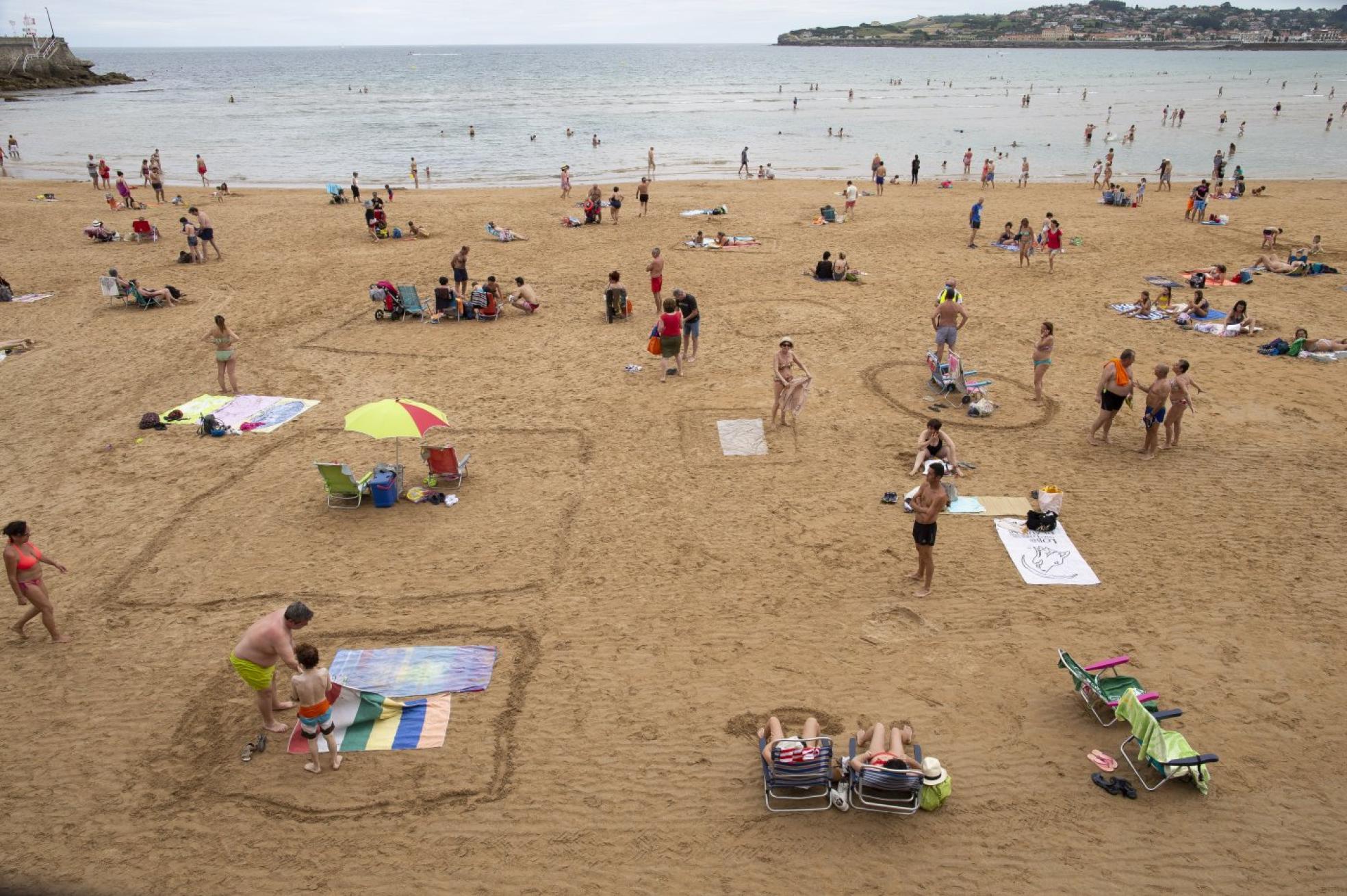 La playa de San Lorenzo, en el verano de 2020, con varias parcelas dibujadas sobre la arena. 
