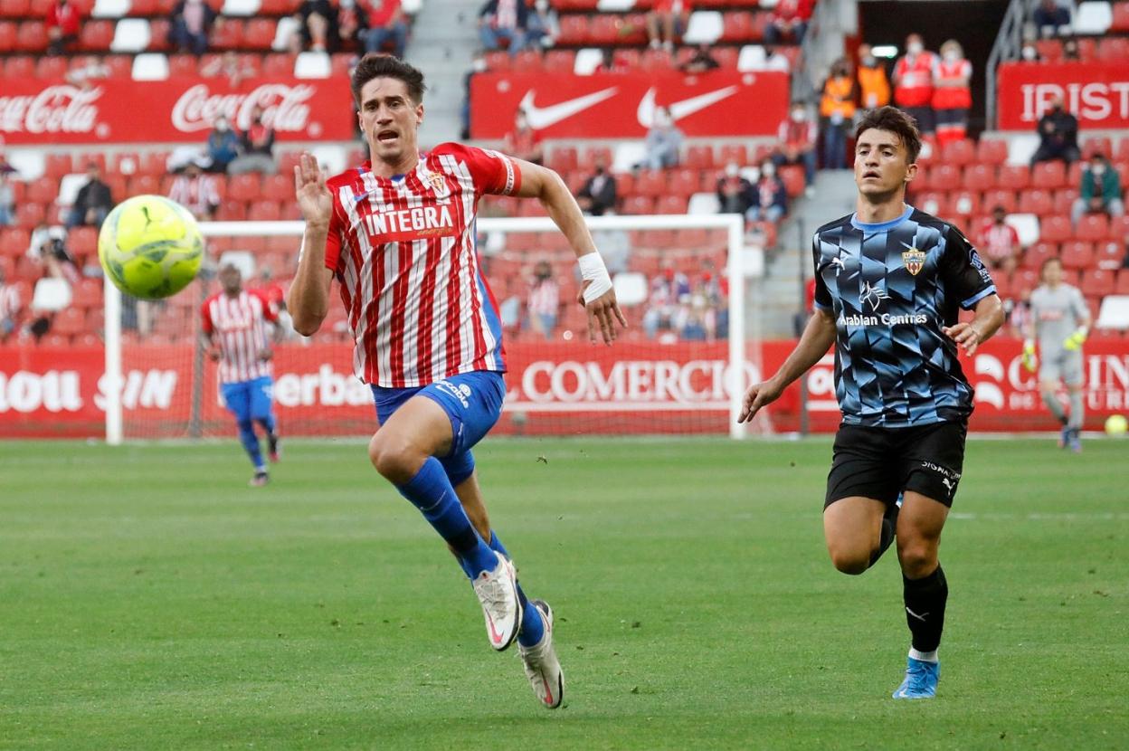 Pablo Pérez disputa un balón a un jugador del Almería en el encuentro en El Molinón. 