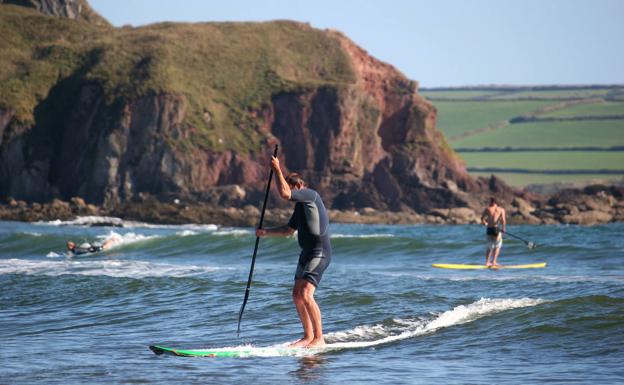 Explorar grutas costeras subido en una tabla de paddel surf, una experiencia única 