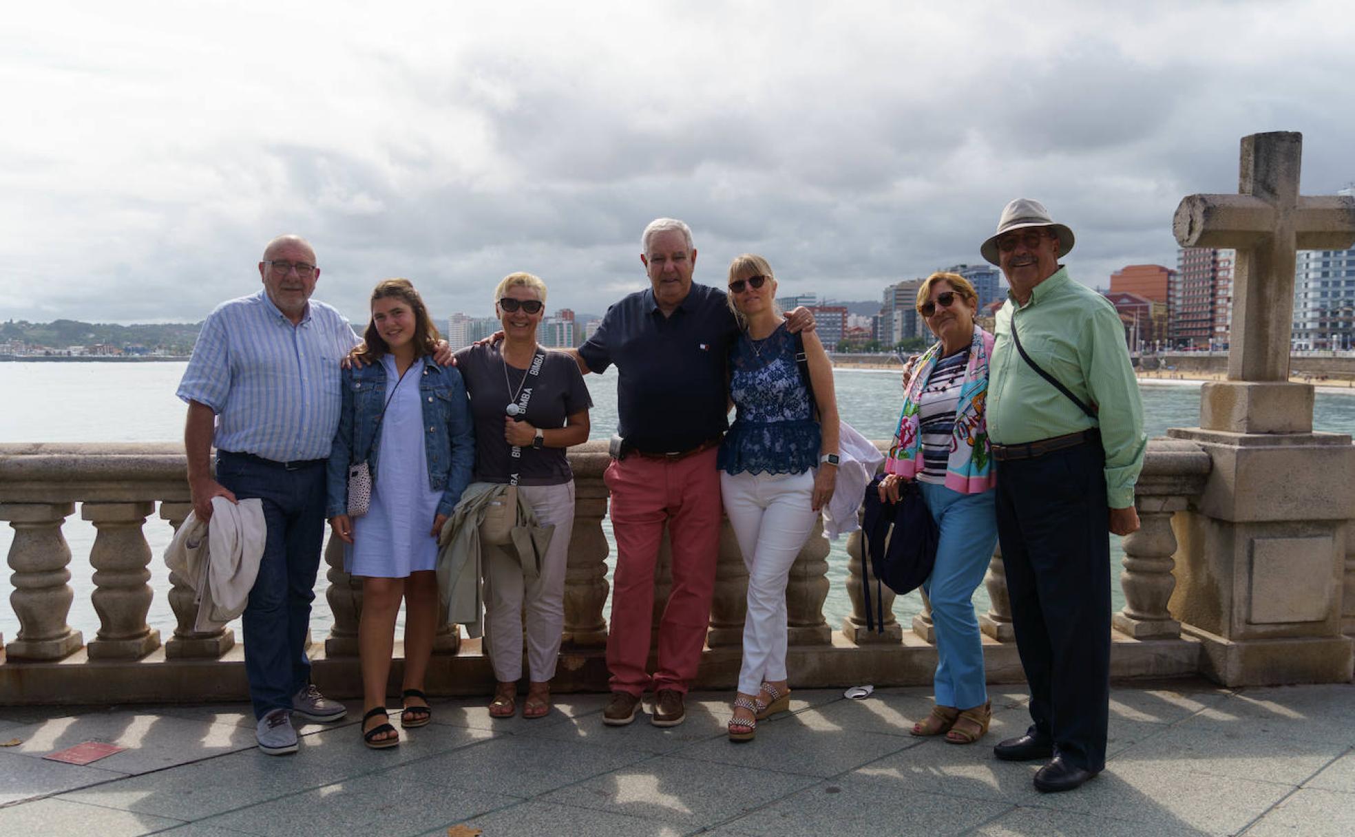 San Lorenzo. Un grupo de canarios, de visita por primera vez en la ciudad, posa junto a sus amigos gijoneses con la playa a su espalda. 