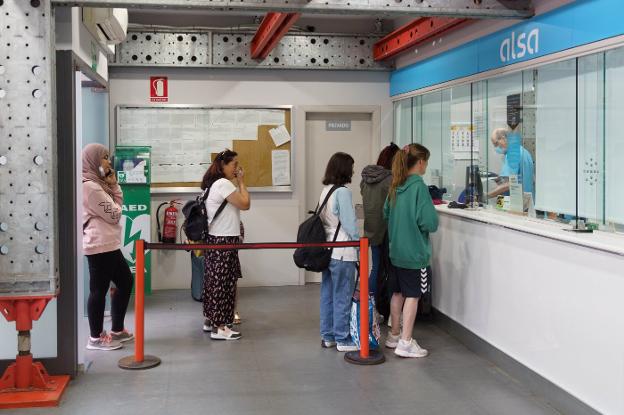 Usuarios del autobús en la taquilla de la estación de Gijón. 