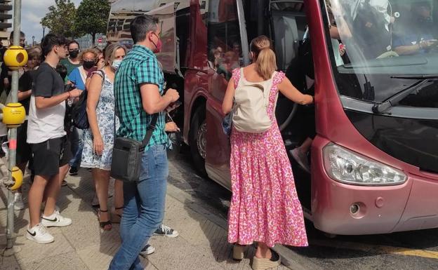 Primeros afectados por el corte del ferrocarril subiendo a los autobuses fletados por Renfe. 