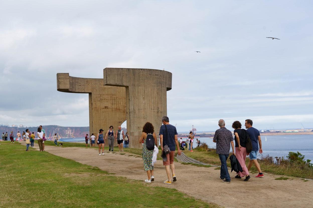 Numerosos gijoneses y visitantes, paseando a media mañana por el entorno del 'Elogio del Horizonte'. 