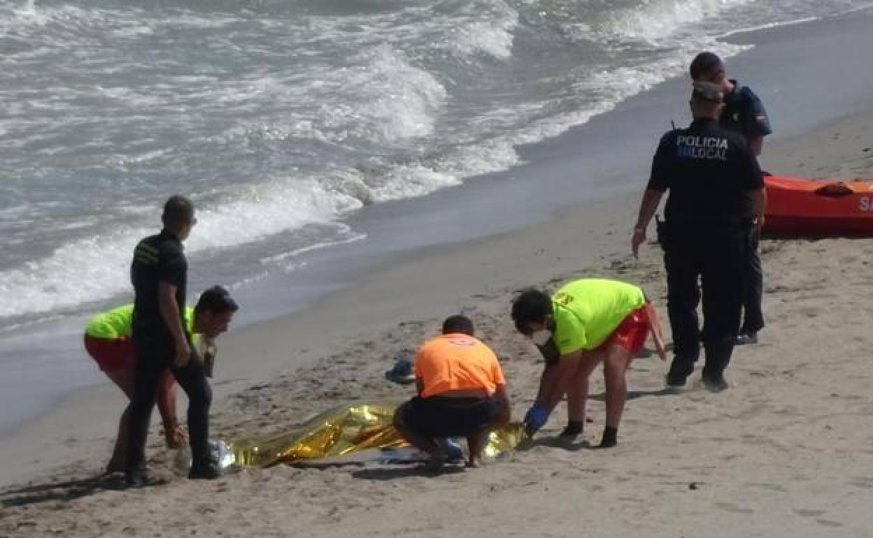 Agentes de la Policía Local y de Salvamento, junto a uno de los cuerpos hallados en La Manga. 