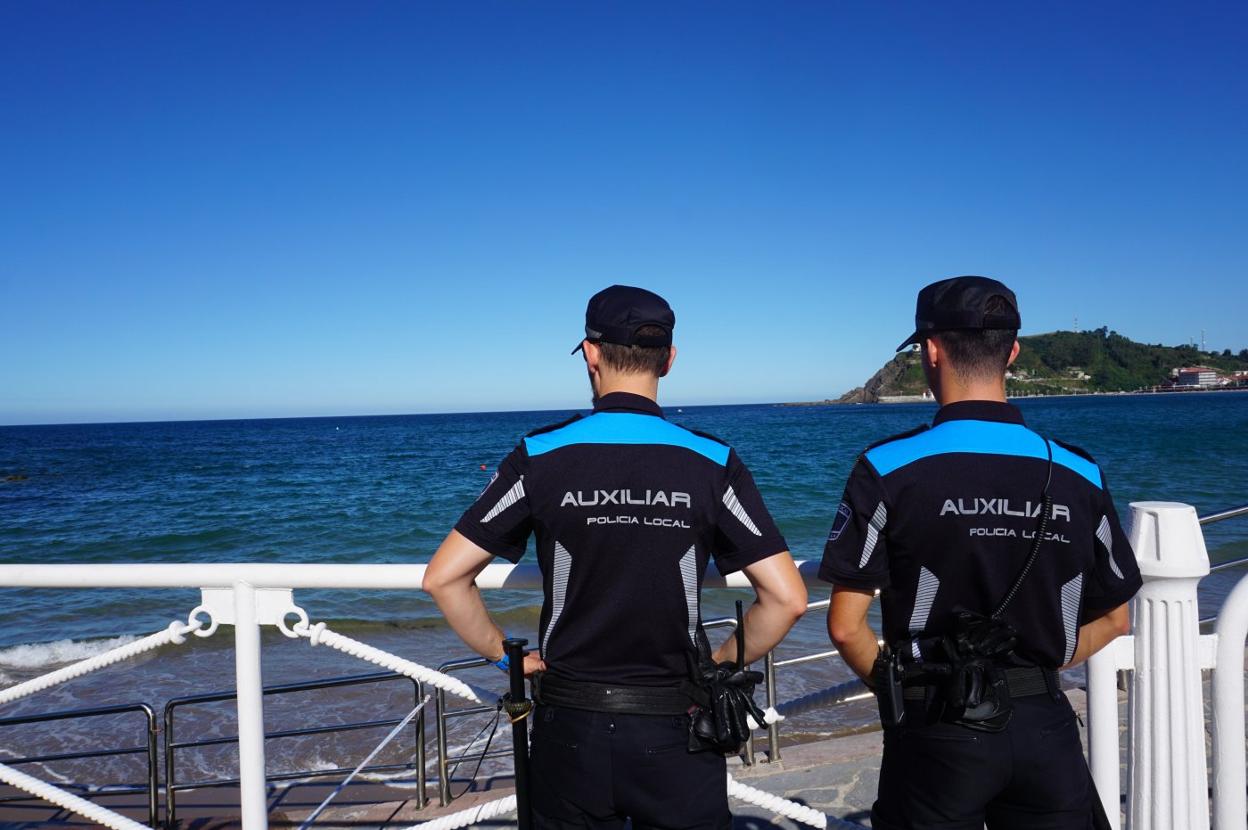 Agentes de la Policía Local, frente a la boya que señaliza la granada. 
