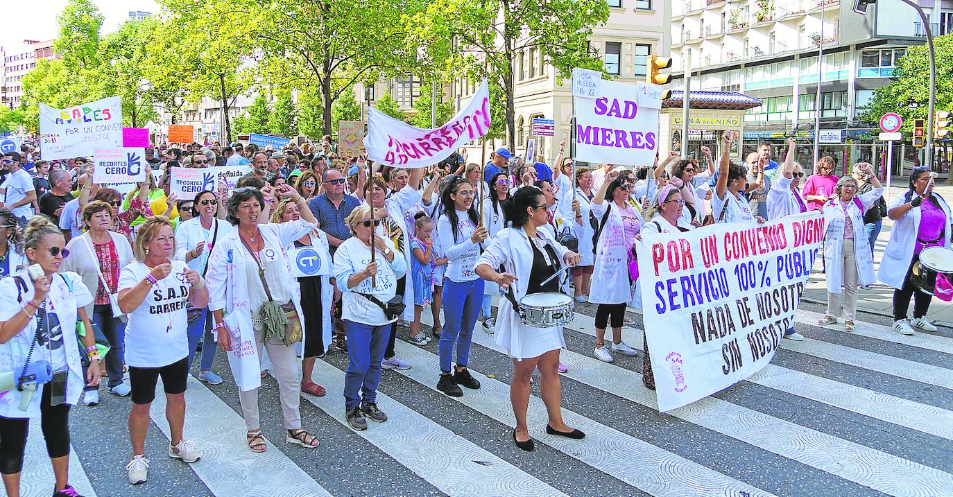 Centenares de profesionales del servicio de ayuda a domicilio, acompañadas por varias asociaciones y usuarios, al inicio de la protesta. alberto sánchez