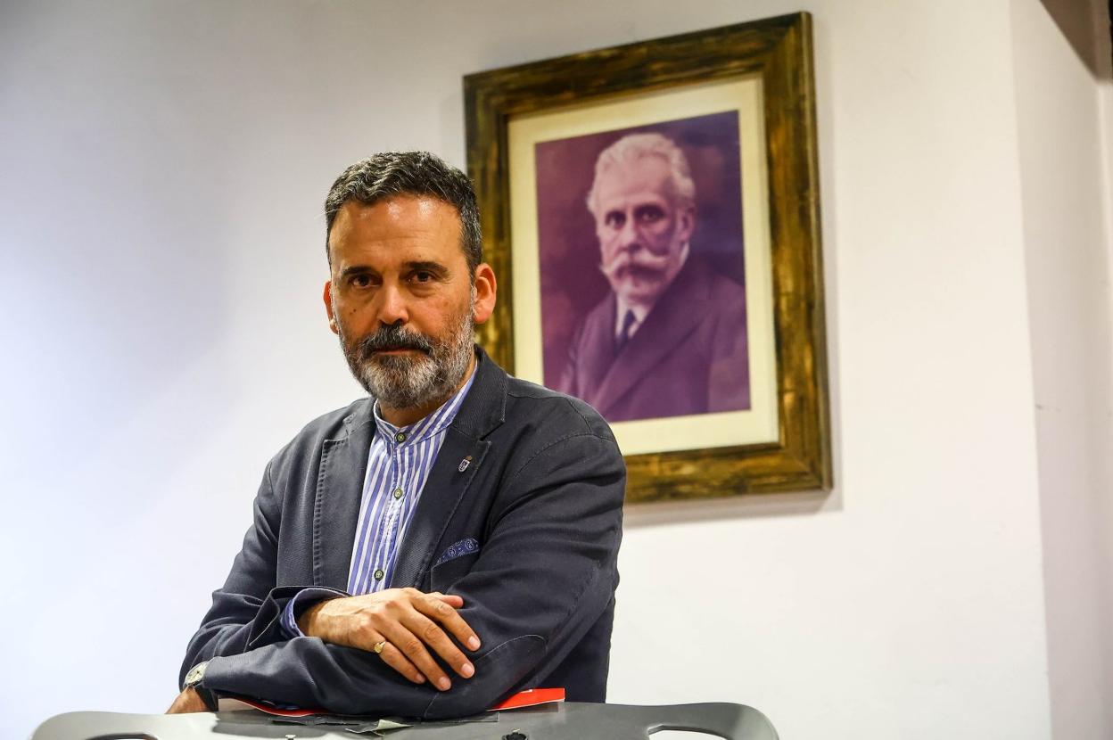 El candidato a las primeras del PSOE, Ricardo Fernández, posa para EL COMERCIO en la AMSO, frente a un retrato de Pablo Iglesias. 