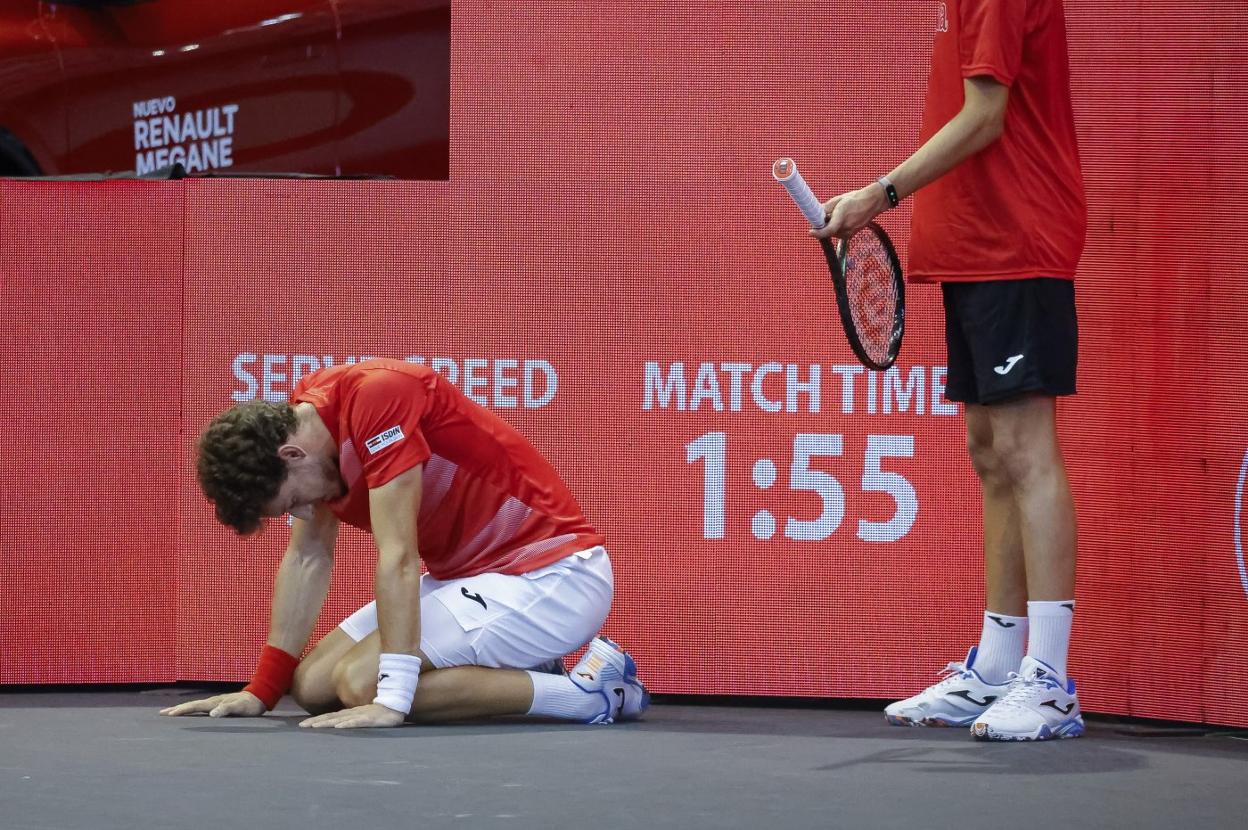 Pablo Carreño, derrumbado tras uno de los puntos, mientras un recogepelotas le sostiene su raqueta. 