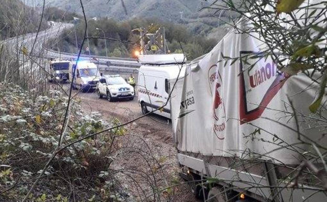 El camión accidentado, junto a una ambulancia y dotaciones de la Guardia Civil, Bomberos, y del centro de control de autopistas. 