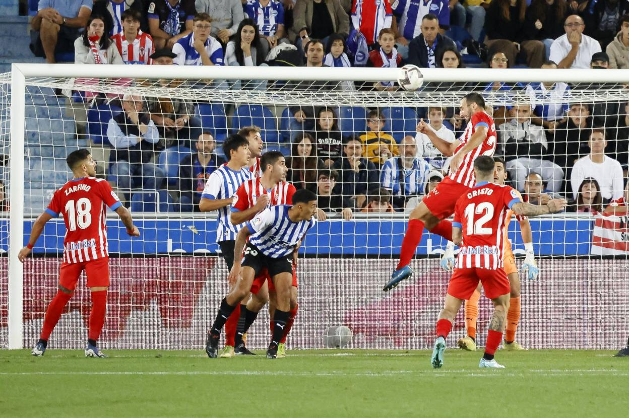El central Izquierdoz despeja con contundencia un balón aéreo en el área del Sporting. 