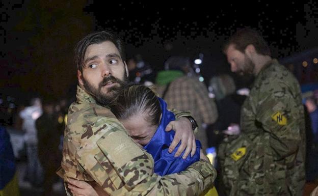 Un soldado abraza a una mujer envuelta en la bandera de Ucrania en plena Guerra