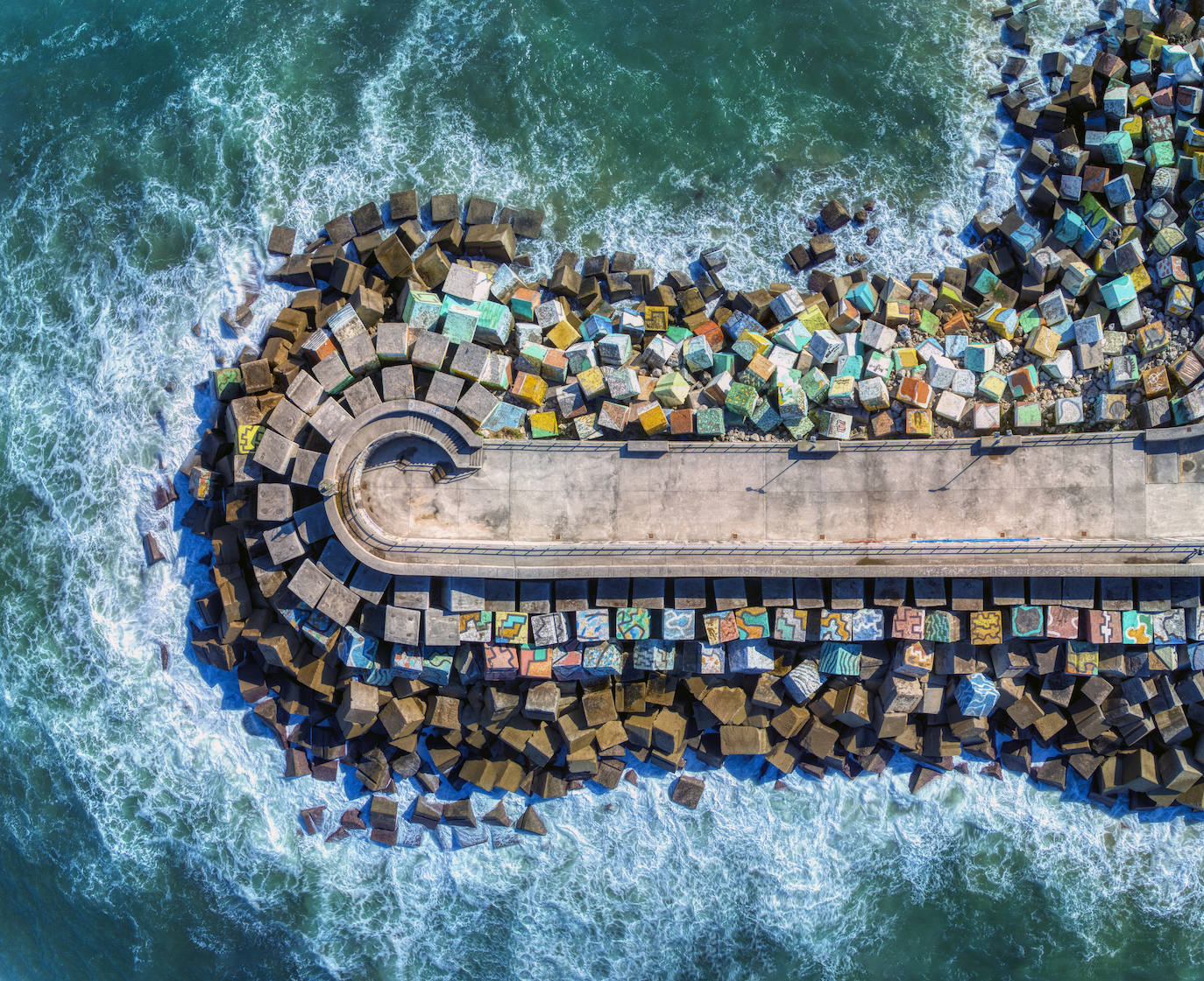 Vista aérea de los Cubos de la Memoria, intervención artística en el puerto marinero ideada por Agustín Ibarrola. Los cubos de hormigón que tradicionalmente conforman las escolleras están en este caso pintados de colores que permiten jugar con la armonía de sus formas. 