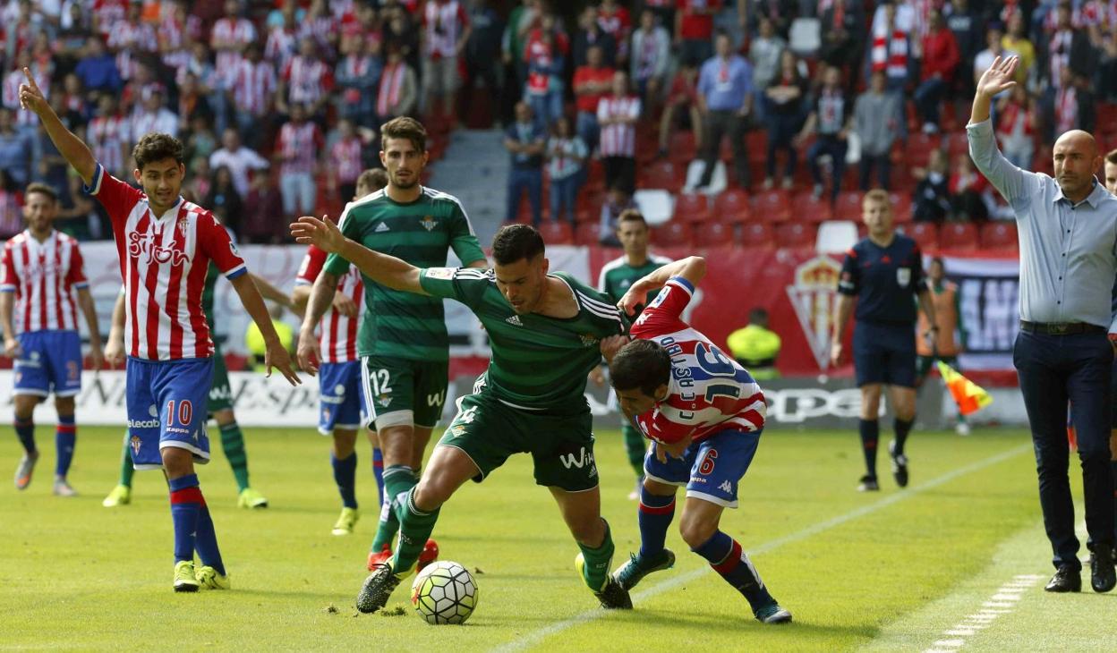 Bruno, en su etapa con el Betis, protege el balón ante la presión de Carlos Castro, con Abelardo siguiendo la jugada en la banda. 