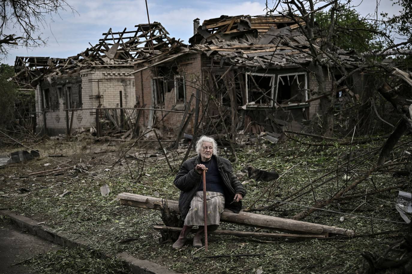 na mujer anciana sentada frente a casas destruidas después de un ataque con misiles en la ciudad de Druzhkivka, en la región de Donbas. 