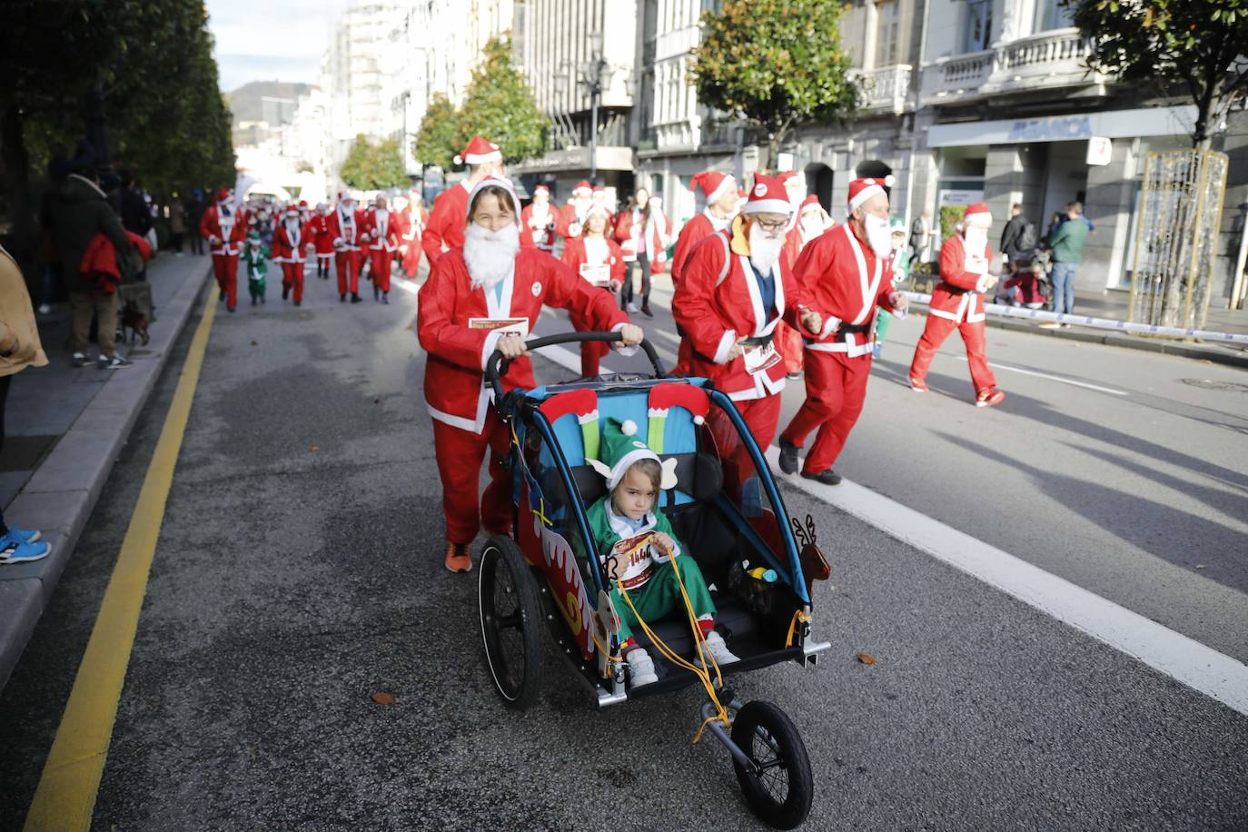 Fotos: Marea roja de Papás Noel por las calles de Oviedo