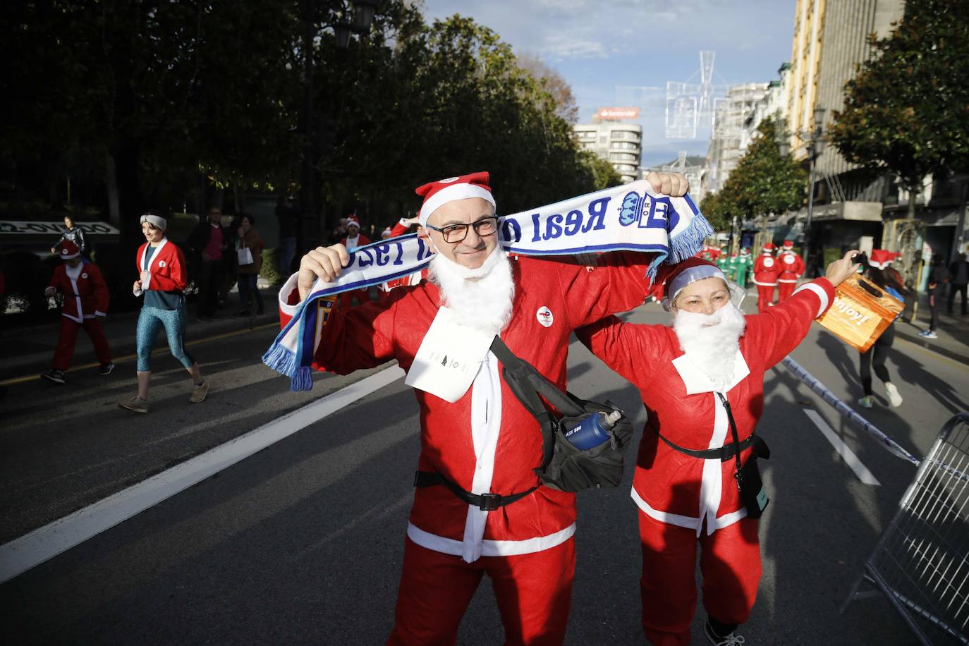 Fotos: Marea roja de Papás Noel por las calles de Oviedo