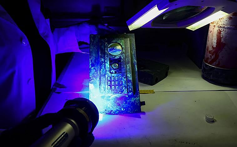 Imagen principal - En la primera imagen, búsqueda de huellas mediante una potente luz tras la aplicación de sustancias reveladoras. Debajo, recogida de perfiles de ADN en un cuchillo y colocación testigos para marcar una huella.