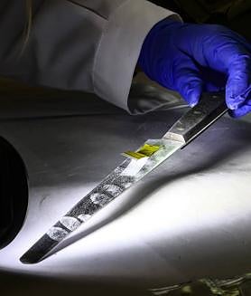 Imagen secundaria 2 - En la primera imagen, búsqueda de huellas mediante una potente luz tras la aplicación de sustancias reveladoras. Debajo, recogida de perfiles de ADN en un cuchillo y colocación testigos para marcar una huella.