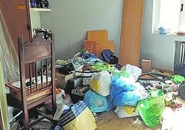 Una de las habitaciones del piso con muebles y cosas rotas.