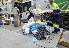 Dos camiones de Cogersa retirando la basura acumulada junto a los buzones de los contenedores soterrados en Donato Argüelles.