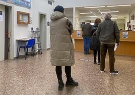 Usuarios del centro de salud de Perchera, en Gijón, aguardan su turno para ser atendidos en el área de administración.